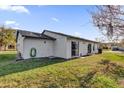 Exterior rear of a house featuring a well-kept lawn, with sliding glass doors and back entry at 4804 Laddie Ct, Orlando, FL 32821