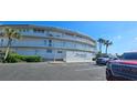 Exterior view of Surfside condos with sign, palm trees, and parking at 4831 Saxon Dr # 1130, New Smyrna Beach, FL 32169