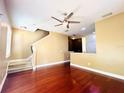 Bright living room with hardwood floors, ceiling fan, and staircase leading to upper level of home at 5 W Harding St # E, Orlando, FL 32806