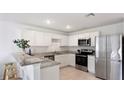 Modern kitchen with white cabinetry, stainless steel appliances, and granite countertops at 545 Jerry Ln, Haines City, FL 33844