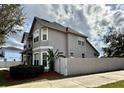 Side view of a well-maintained two-story home with a fenced yard and lush landscaping at 546 Nogales Ct, Kissimmee, FL 34758