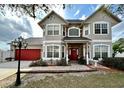 Beautiful two-story home featuring a red front door with brick accents and a red two-car garage door at 546 Nogales Ct, Kissimmee, FL 34758