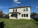 Two-story home featuring a covered patio and lush green backyard on a sunny day at 7606 Loon Ave, Winter Garden, FL 34787