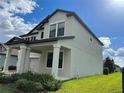 Two-story home featuring a covered front porch with stately columns and manicured shrubbery at 7606 Loon Ave, Winter Garden, FL 34787