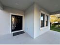 Welcoming front porch with a black front door framed by white trim and sidelight windows at 7606 Loon Ave, Winter Garden, FL 34787