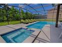 Inviting screened-in pool area with a spa and several lounge chairs for relaxing outdoors at 9114 Stromboli Ct, Kissimmee, FL 34747