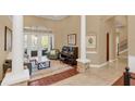 Spacious living area with tile and wood floors, columns, and doors to the outdoor pool area at 10742 Boca Pointe Dr, Orlando, FL 32836