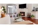 Cozy living room with hardwood floors, a fireplace, and a view of the front entrance at 1165 Cardinal Creek Pl, Oviedo, FL 32765