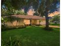 Charming single-story home boasts a lush landscaped yard with mature trees and a cozy, inviting facade at 1224 Shorecrest Cir, Clermont, FL 34711