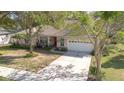 Inviting single-story home featuring a two-car garage, landscaped front yard, and a concrete driveway at 1224 Shorecrest Cir, Clermont, FL 34711