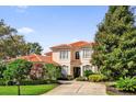 Charming two-story home with a red tile roof, lush landscaping, and a long driveway at 1246 Pallister Ln, Lake Mary, FL 32746