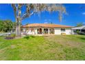 Charming single-story home with a tile roof and well-maintained lawn at 14 E Cypress St, Davenport, FL 33837