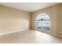 Neutral living room featuring tile flooring, large window with arch and great natural light at 15318 Harvest Blvd, Clermont, FL 34714