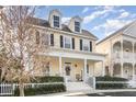 Attractive two-story yellow home with a covered porch and manicured hedge in front at 206 Norfolk Pl, Kissimmee, FL 34747