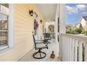 Inviting front porch with seating and a decorative wreath on the front door of this charming home at 206 Norfolk Pl, Kissimmee, FL 34747