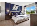 Beautiful bedroom featuring an accent wall, stylish decor, and a large window at 2230 Lake Preserve Cir, New Smyrna Beach, FL 32168