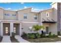 A contemporary townhome featuring a well-maintained exterior, green lawn, and modern architectural details at 2377 Reading Trl, Kissimmee, FL 34746