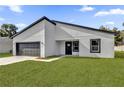 Angle view of modern house featuring a gray garage door and minimalist design at 420 Marion Oaks Crse, Ocala, FL 34473