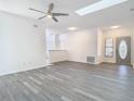 Bright living room with wood-look flooring, modern ceiling fan, and natural light from the skylights at 4371 Weeping Willow Cir, Casselberry, FL 32707