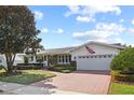 Inviting home showcasing a brick driveway leading to an attached garage and landscaped front yard at 625 Brechin Dr, Winter Park, FL 32792