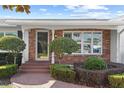 Close-up of the brick-paved entryway with decorative columns and trimmed hedges at 625 Brechin Dr, Winter Park, FL 32792