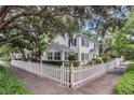 Charming two-story home featuring manicured landscaping and a classic white picket fence at 728 N Summerlin Ave, Orlando, FL 32803