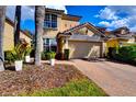 A sunny shot of this house with an attached garage and paved driveway at 8443 Via Bella Notte, Orlando, FL 32836