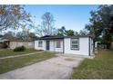 Charming single-story home with a well-manicured front yard and a gray concrete driveway leading to the front door at 913 Lake Ave, Edgewater, FL 32132