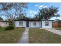 Charming single-story home with a well-manicured front yard and a gray concrete walkway leading to the front door at 913 Lake Ave, Edgewater, FL 32132