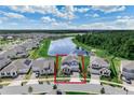 Aerial view of a blue two-story home near a lake surrounded by lush green spaces at 9752 Petition Way, Orlando, FL 32832