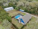 Aerial view of a home with a screened-in pool, separate garage and surrounded by lush trees at 1134 Glenwood Rd, Deland, FL 32720