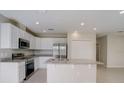 Bright kitchen featuring white cabinetry, stainless steel appliances, and a granite island at 124 Appian Way, Kissimmee, FL 34758