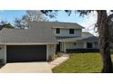 Charming two-story home featuring a gray roof and light green siding with a two car garage at 124 Godfrey Rd, Edgewater, FL 32141