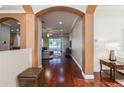 Welcoming foyer with arched doorways, gleaming hardwood floors, and neutral paint, opening to the living areas at 182 Crepe Myrtle Dr, Groveland, FL 34736