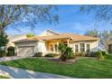 Inviting single-story home with lush green lawn, brick driveway, and well-maintained landscaping at 182 Crepe Myrtle Dr, Groveland, FL 34736