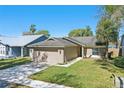 Beautiful single-story home with a manicured lawn and a two-car garage under a clear blue sky at 2439 Lake Jackson Cir, Apopka, FL 32703