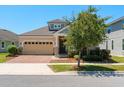 Inviting curb appeal with a brick driveway, stone accents, and a well-maintained lawn and shrubbery at 2890 Avian Loop, Kissimmee, FL 34741