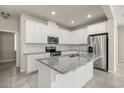 Modern kitchen featuring white cabinets, stainless steel appliances, and a large center island with granite countertops at 2890 Avian Loop, Kissimmee, FL 34741