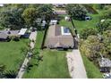 An aerial view showcasing a well-maintained lot with a screen-enclosed pool and long driveway at 290 Orange Ave, St Cloud, FL 34769
