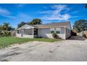 Exterior view showcasing the house's side profile with a screen porch and a long driveway with ample parking at 290 Orange Ave, St Cloud, FL 34769