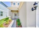 Inviting front porch with a decorative wreath on the door and manicured landscaping at 3811 Lana Ave, Davenport, FL 33897