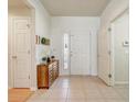 Bright foyer featuring tiled floors, a decorative cabinet, and a view of the front door with glass inserts at 3995 Sw 57Th Ct, Ocala, FL 34474