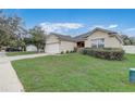 Residential home featuring a well-kept lawn, attractive landscaping, and a two-car garage in a friendly neighborhood at 3995 Sw 57Th Ct, Ocala, FL 34474
