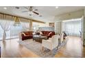 Spacious living room with wood floors, large windows, neutral décor, and comfortable seating arrangements at 3995 Sw 57Th Ct, Ocala, FL 34474
