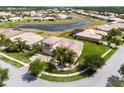 Overhead view of a home with a paver driveway, lush lawn, mature trees, and nearby pond at 4058 Navigator Way, Kissimmee, FL 34746