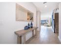 Inviting hallway with tile flooring, a decorative table, and a glimpse into the living room at 4374 Rhyme St, Kissimmee, FL 34746