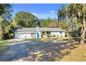 Inviting single-story home with a paved driveway, lush lawn and a small American flag at 530 Mckenzie Rd, Lake Helen, FL 32744