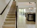 Bright interior with stairs, tile flooring, open kitchen, and sliding doors to patio at 8141 Roseville Blvd, Davenport, FL 33896