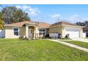 Home with a manicured lawn, and a decorative bridge and walkway at 600 Park Valley Cir, Minneola, FL 34715