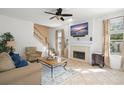 Cozy living room showcasing neutral tones, a fireplace, and an adjacent staircase at 10400 Windermere Chase Blvd, Gotha, FL 34734